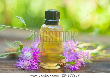 Essence Of Lavender Flowers On Table In Beautiful Glass Bottle