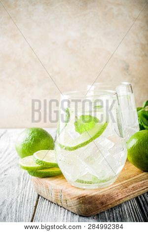Summer Sour Drink, With Lime And Mint, Homemade Cocktail Mojito In Two Glasses, White Wooden Backgro