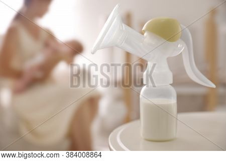 Mother And Little Baby Indoors, Focus On Table With Breast Pump