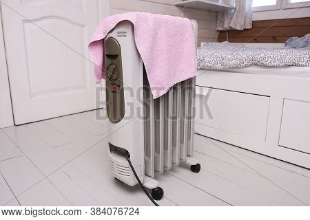 A Dangerous Hazardous Situation With Mobile Oil Heater Covered With A Towel, That Is Dryin On A Hot 