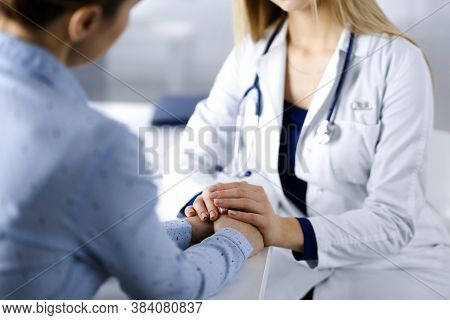 Unknown Woman-doctor Is Holding Her Patients Hands To Reassure The Patient, Discussing Current Healt