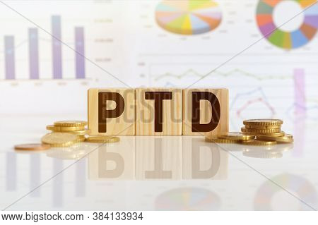 Ptd The Word On Wooden Cubes, Cubes Stand On A Reflective Surface, In The Background Is A Business D