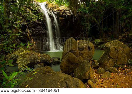 Tropical Landscape. Beautiful Hidden Waterfall In Rainforest. Foreground With Big Stones. Adventure 