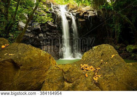 Tropical Landscape. Beautiful Hidden Waterfall In Rainforest. Foreground With Big Stones. Adventure 