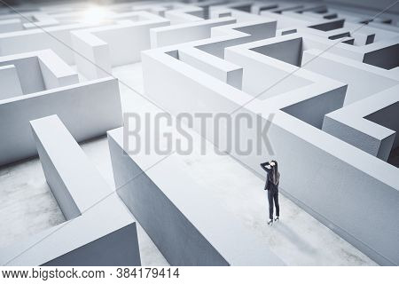 Young Businesswoman In Suit Standing In Concerete Labyrinth. Business And Challenge Concept.