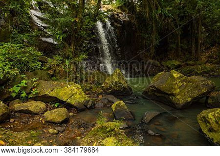 Tropical Landscape. Beautiful Hidden Waterfall In Rainforest. Foreground With Big Stones. Adventure 