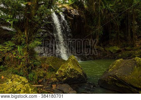Tropical Landscape. Beautiful Hidden Waterfall In Rainforest. Foreground With Big Stones. Adventure 