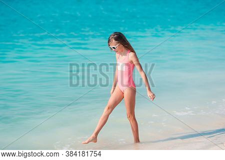 Adorable Active Little Girl At Beach During Summer Vacation