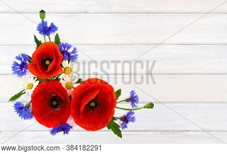 Red Poppies, Cornflowers And Chamomile On Background Of White Painted Wooden Planks With Space For T
