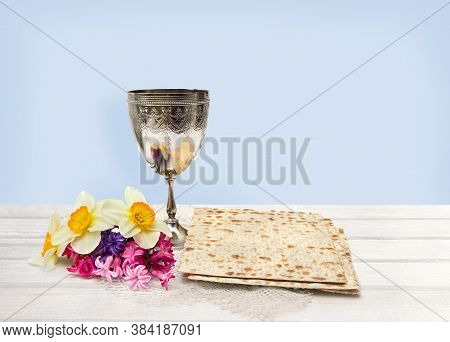 Matzo, Wine And Narcissus With Hyacinths For Passover Celebration On White Wooden Table On Blue Back