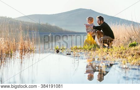 Father With Small Son Collecting Rubbish Outdoors In Nature, Plogging Concept.