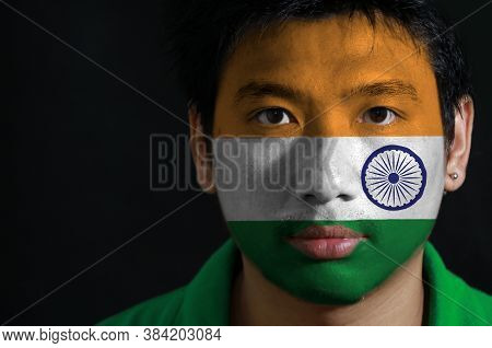 Portrait Of A Man With The Flag Of The India Painted On His Face On Black Background. Tricolor Of In