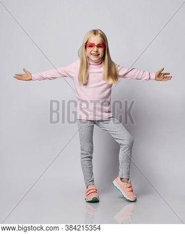 Cute Smiling Blonde Kid Girl In Stylish Smoked Heart-shaped Sunglasses And Wool Thermal Underwear Tu