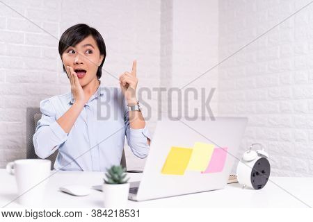 Happy Woman Sitting At Home Office And Pointing To Copy Space