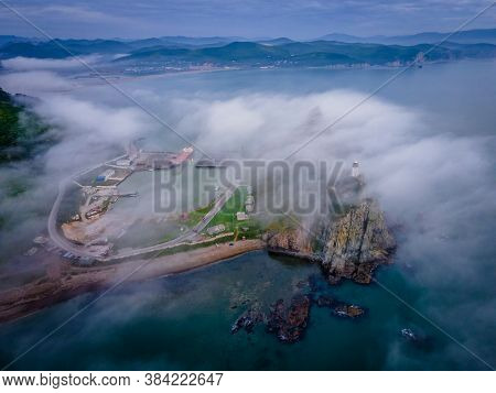 View From Above. Beautiful Cape Briner With Rudny Lighthouse On The Background Of Morning Fog
