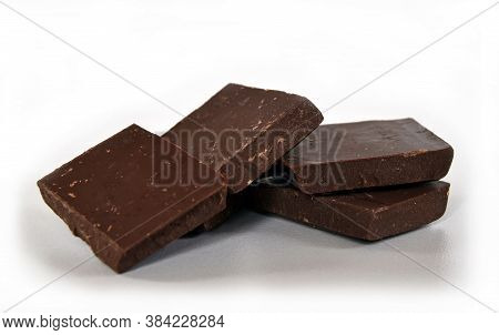 Dark Chocolate Cubes Tower On White Background. Close-up View.
