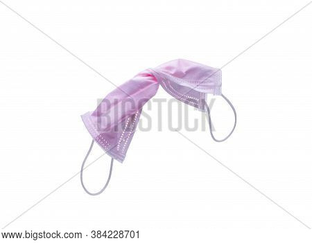 Used Pink Surgical Face Mask Isolated On White Background With Copy Space. Medical Waste. Infectious