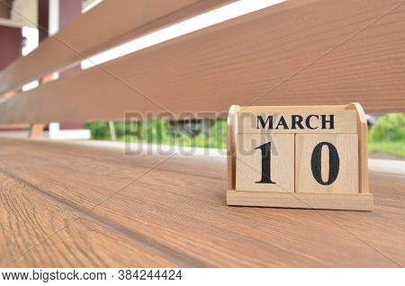 March 10, Number Cube With Wooden Balcony Background.