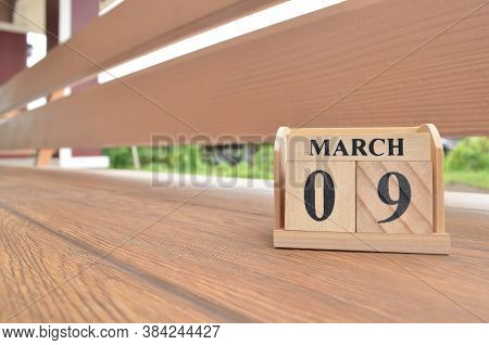 March 9, Number Cube With Wooden Balcony Background.