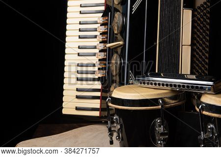 Old Accordion, Harmonica And Bong On Rustic Wooden Surface With Black Background And Low Key Lightin