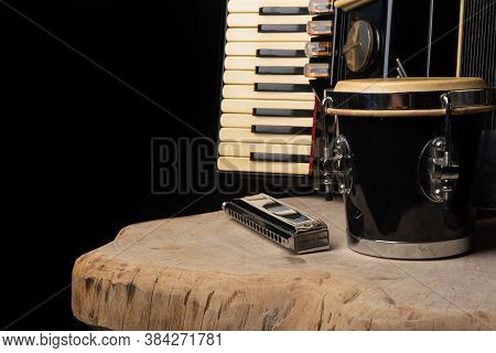 Old Accordion, Harmonica And Bong On Rustic Wooden Surface With Black Background And Low Key Lightin
