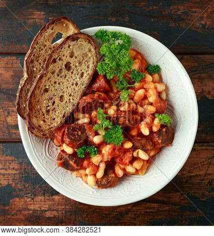 Bean And Chorizo Stew Served In White Bowl With Parsley