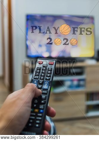 Man Holding A Remote Control While Watching Basketball Playoffs 2020 On Tv