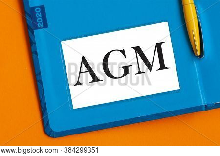 The Word Agm Is Written In Black Marker On The White Paper For Notes. Agm - Annual General Meeting