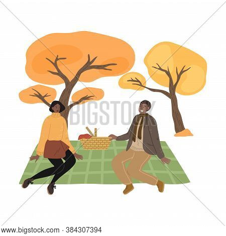 Young Couple Sitting On Ground, Having Picnic And Enjoying Life In Autumn Park