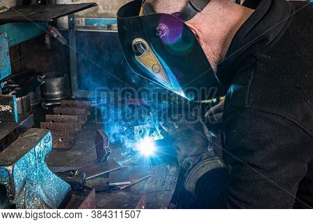 Electric Welding Process. Worker In Welding Mask. Bright White And Blue.