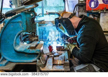 Electric Welding Process. Worker In Welding Mask. Bright White And Blue.