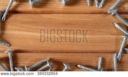 Self-cutters On A Wood Brown Background Banner With Space For Text. Construction Tools, Self-tapping