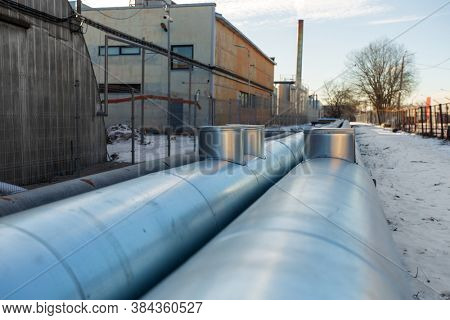 industrial concept - outdoor pipeline and old hangar in winter