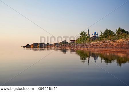 Coast Of The Lake Peipus At Sunset. Church Of The Apostles Peter And Paul In Vetvenik, Pskov Region.