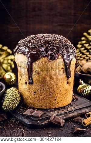 Chocolate Panettone Isolated On Rustic Wooden Background, Space For Text. Typical Christmas Dessert 