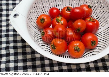 juicy red tomatoes in table cloth . caro background