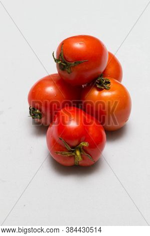 juicy red tomatoes in table cloth . caro background