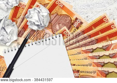100 Sri Lankan Rupees Bills And Balls Of Crumpled Paper With Blank Notepad. Bad Ideas Or Less Of Ins