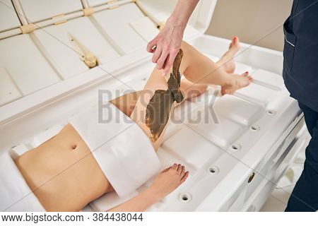 Applying Hydrating Body Mask On The Skin Of Legs