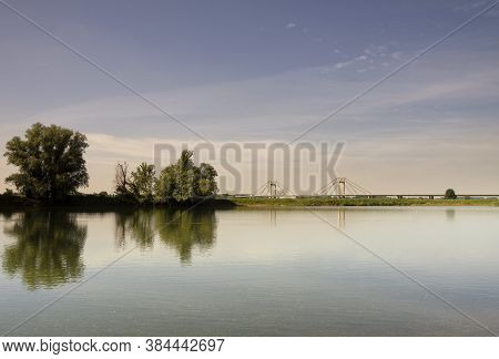 Trees Reflecting In A Large Pond In The Floodplain Of The River Waal Near The Village Echteld