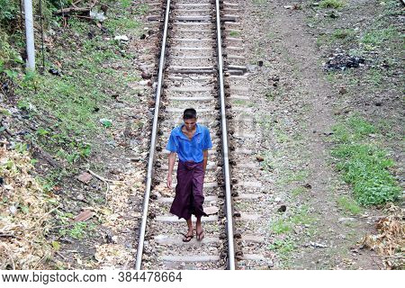 Yangon, Myanmar June 6, 2018: Myanmarese Man Villager In Short Sleeve T Shirt And Long Yi Walking On