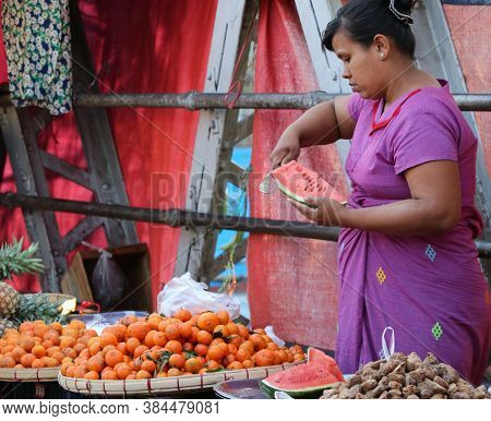 Yangon, Myanmar, Feb 20, 2019 : Myanmese Female Street Vendor Selling Fruits Is Slicing Watermelon A