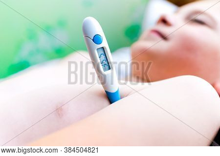 Close Up Side View Flu Sick Lying Down Schoolboy With Medical Thermometer In Armpit Health Illness. 
