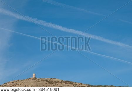 Observation tower and contrails of airplanes in the sky. Santa Eulalia La Mayor. Guara mountains. Huesca. Aragon. Spain.