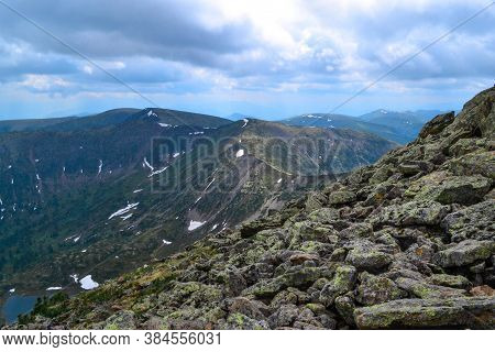 Stones, Rocks On Mountain Ridge, View Of Mountain Lake In Form Of Heart Among Snow Ice Glaciers, Gre