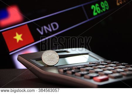 Two Hundred Vietnam Dong Coin On Reverse (vnd) On Black Calculator And  Black Floor With Digital Boa