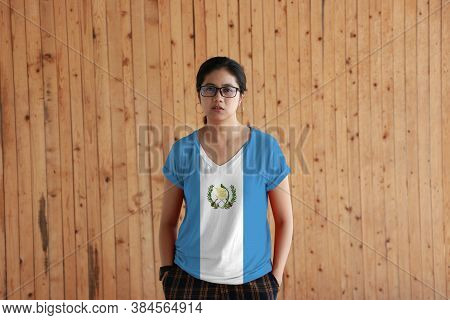 Woman Wearing Guatemala Flag Color Shirt And Standing With Two Hands In Pant Pockets On The Wooden W