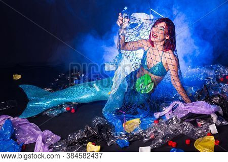 Ocean Plastic Pollution Concept. Mermaid Lives To Polluted Habitat.