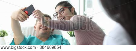 Husband And Wife Take Selfie In Hospital Bed. Doctor Motivates Patient. Single Room Is Equipped With