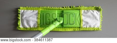 Top View Of Green Mop With Handle For Floor Cleaning. Macro Shot Of Fluffy Rag. Equipment Of Profess